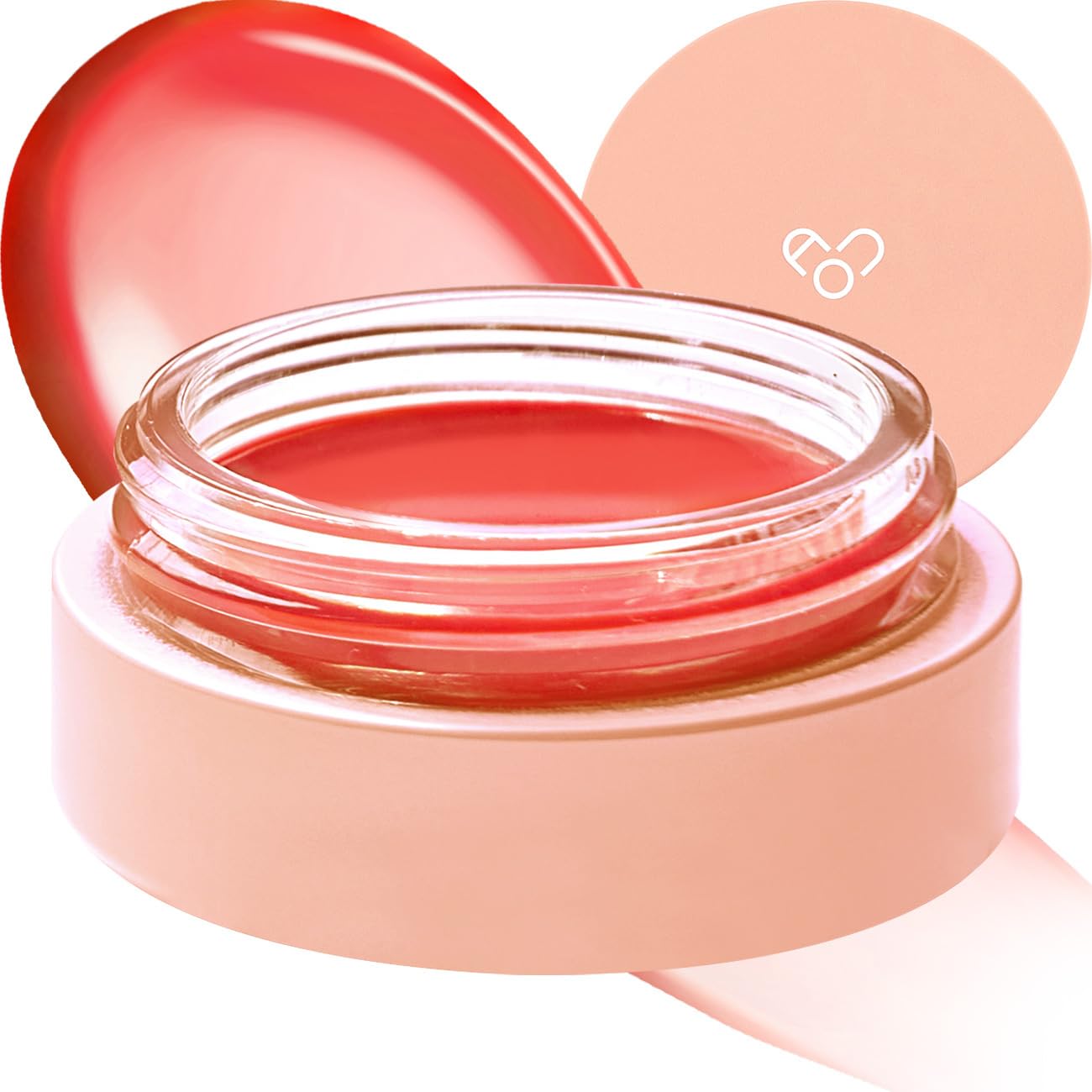 A round jar of red-tinted AOU Lip Balm with a transparent lid, placed on a light peach-colored base. The jar's lid, featuring a simple heart design, is partially visible in the background.