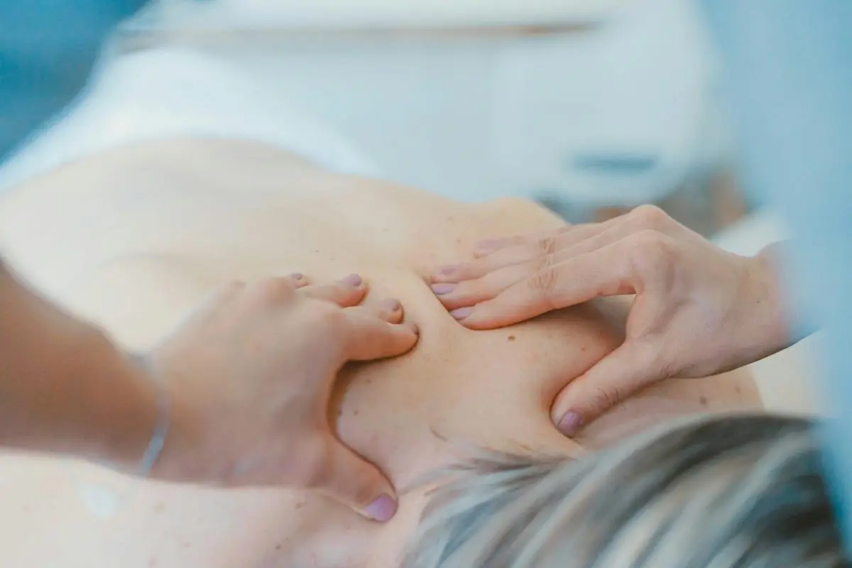 A close-up of a person receiving a Business Trip Massage, with a therapist applying pressure to relieve muscle tension.