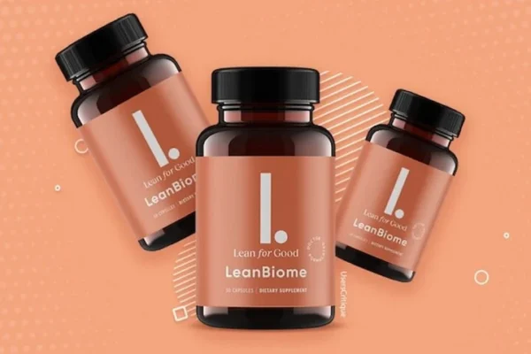 A promotional image of "LeanBiome," a dietary supplement by "Lean for Good." The image features three brown bottles with black caps, each labeled with a minimalist design, including a large white "L." on a peach-colored background. The bottles are arranged dynamically against a matching peach-toned background with abstract circular and geometric patterns. The label indicates that the product contains 30 capsules and is a dietary supplement.