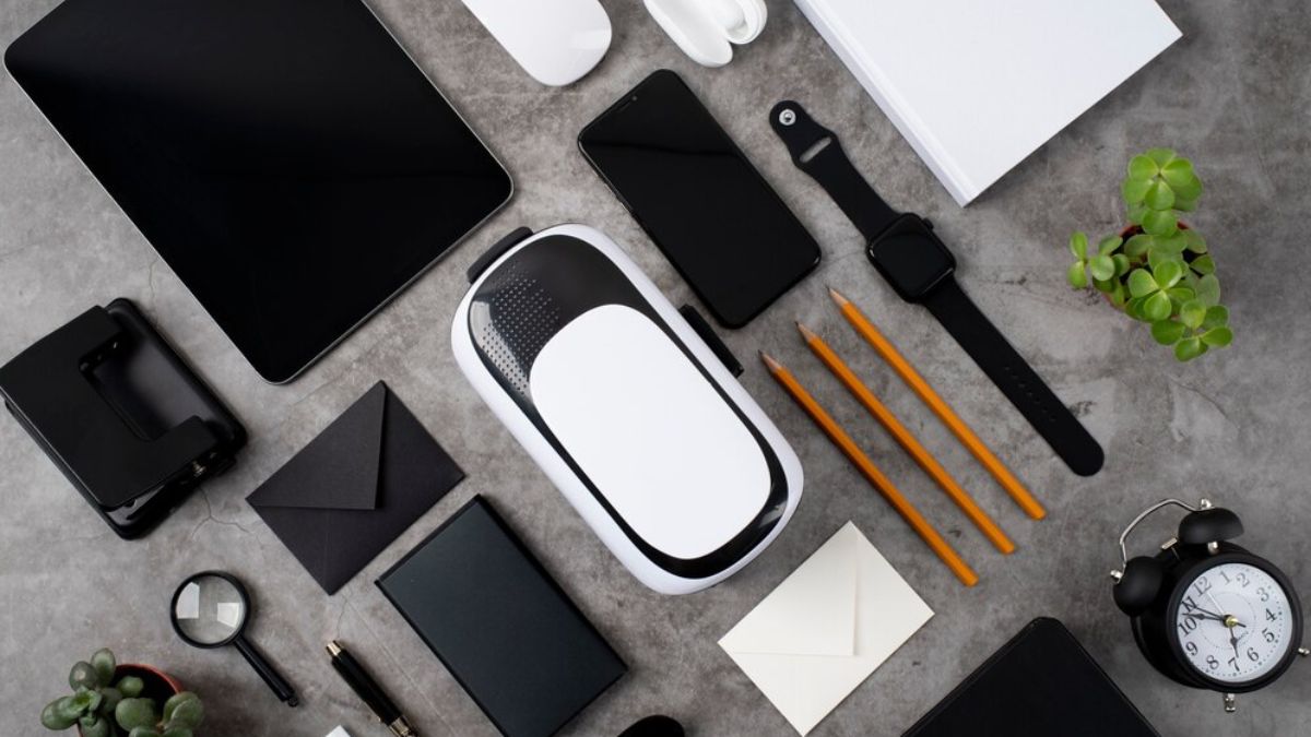 Top view of modern office desk with Future Gadgets 2025 including a VR headset, smartwatch, smartphone, tablet, and eco-friendly accessories.
