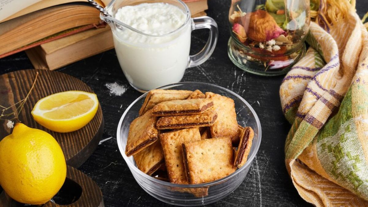 Crunchy golden crackers served with fresh yogurt and lemon, styled on a rustic table—perfect for a wholesome Toastul breakfast.
